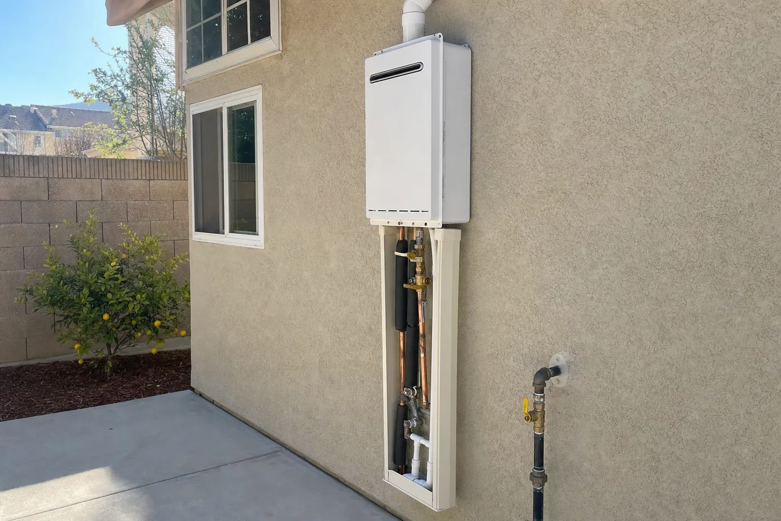 Tankless water heater installation in Temecula, CA on the side of a stucco home