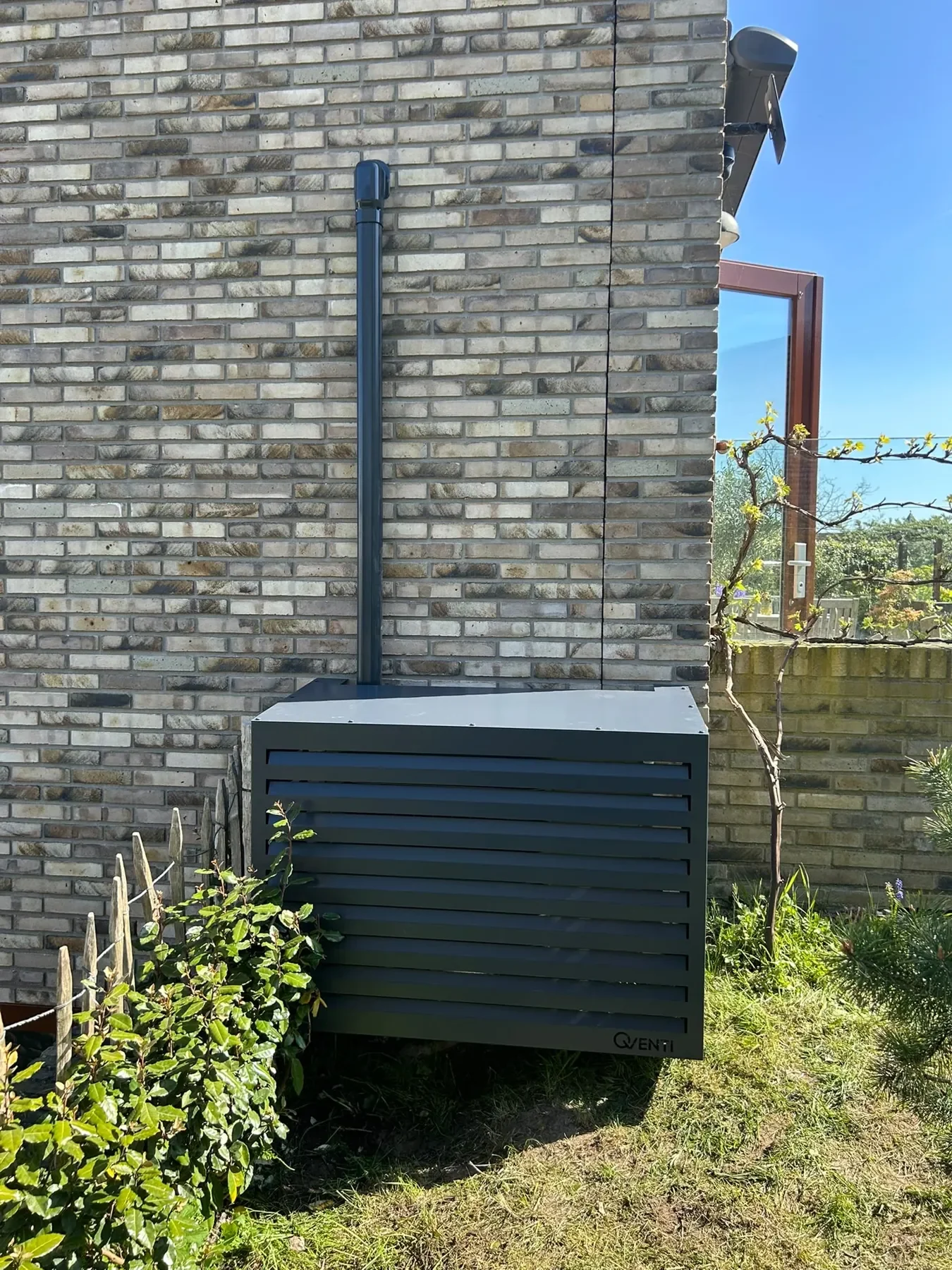 Buitenunit in een strakke omkasting naast de woning