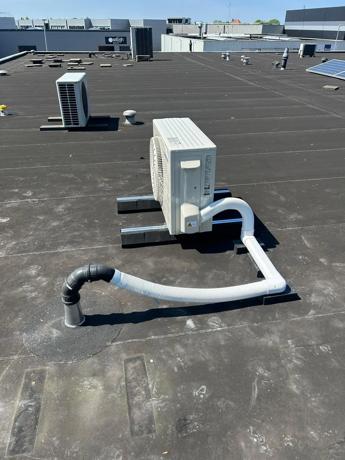 Airco-buitenunit op het dak van een bedrijfspand