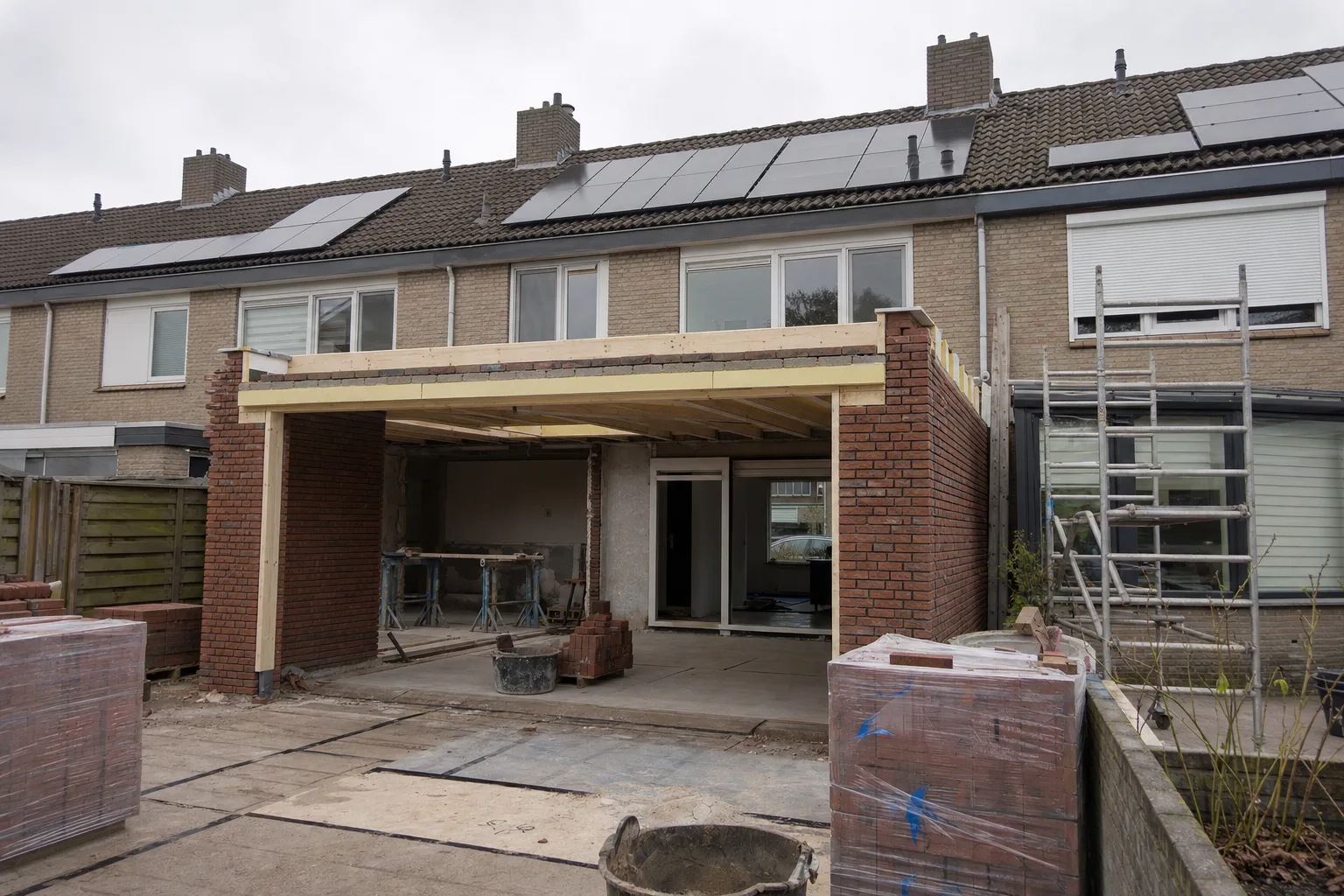 Aanbouw in casco-fase aan de achterkant van een rijtjeshuis: metselwerk en dakbalken