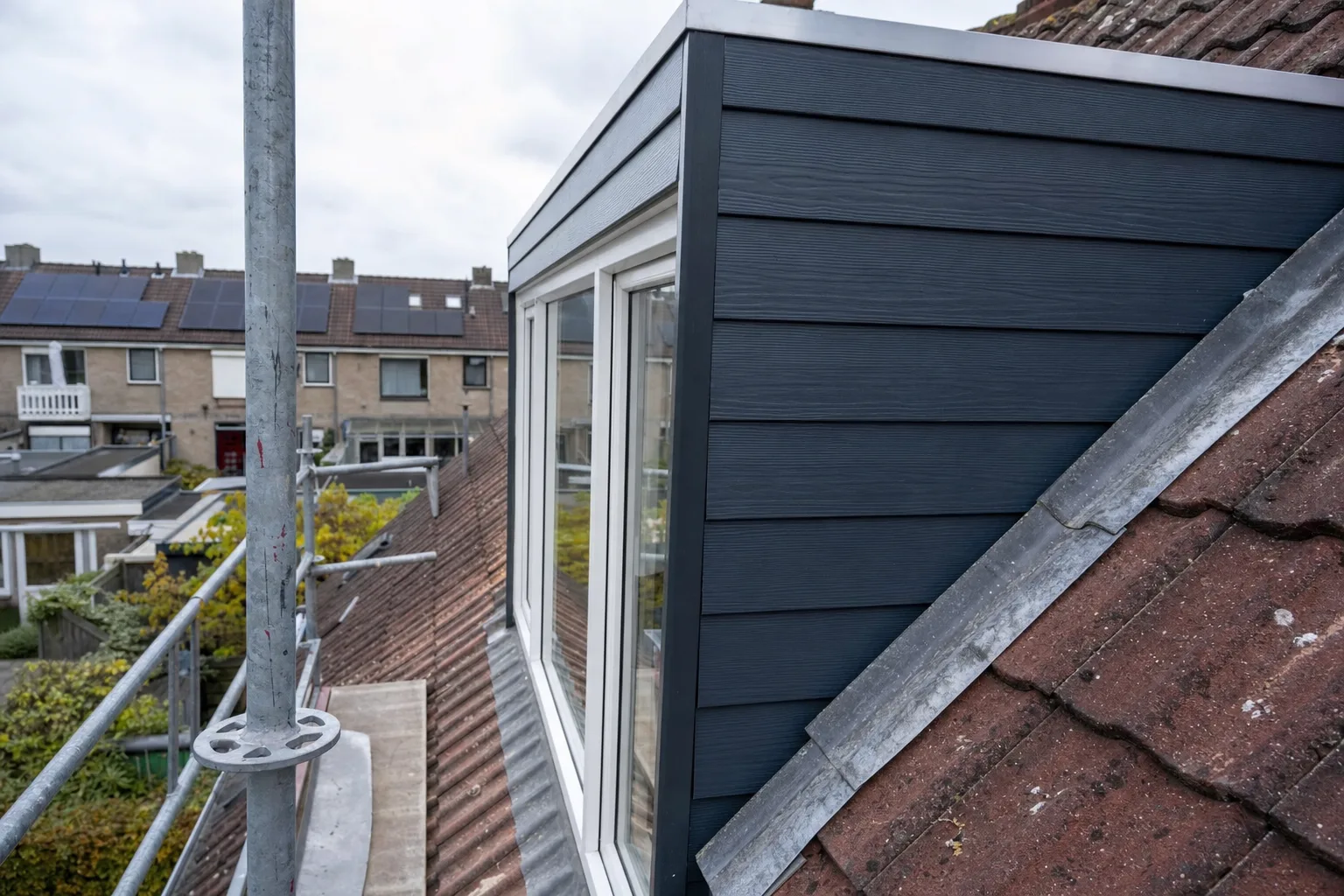 Zijwang van een nieuwe kunststof dakkapel met loodslab op een pannendak in Tilburg