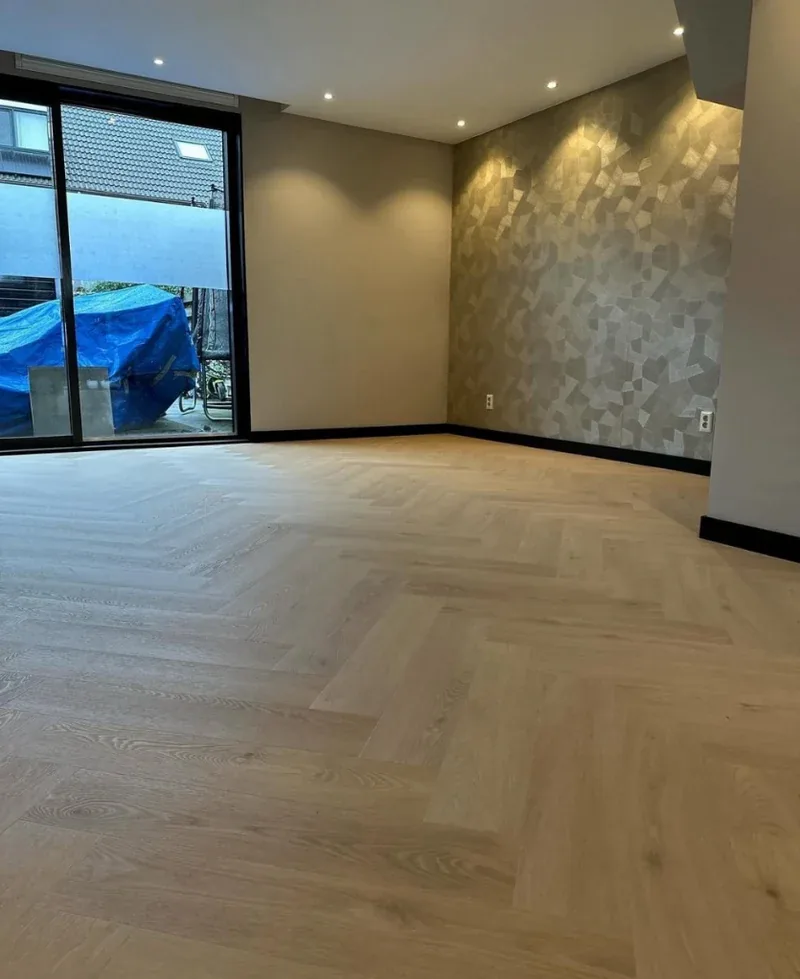 Nieuwbouwwoonkamer met PVC vloer en ledspots in de avond