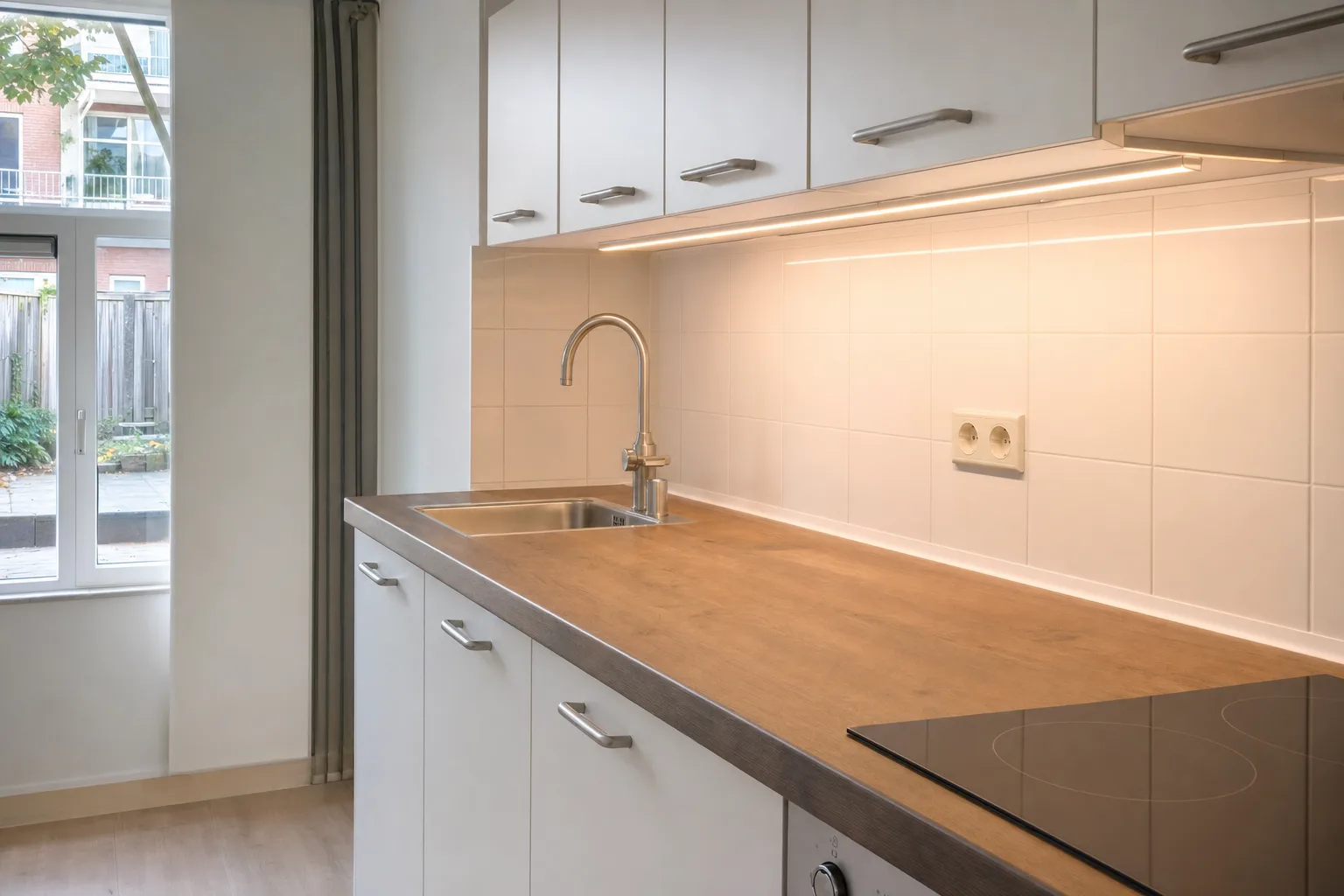 Keuken met afgestelde kastjes en nieuw kitwerk langs het aanrecht