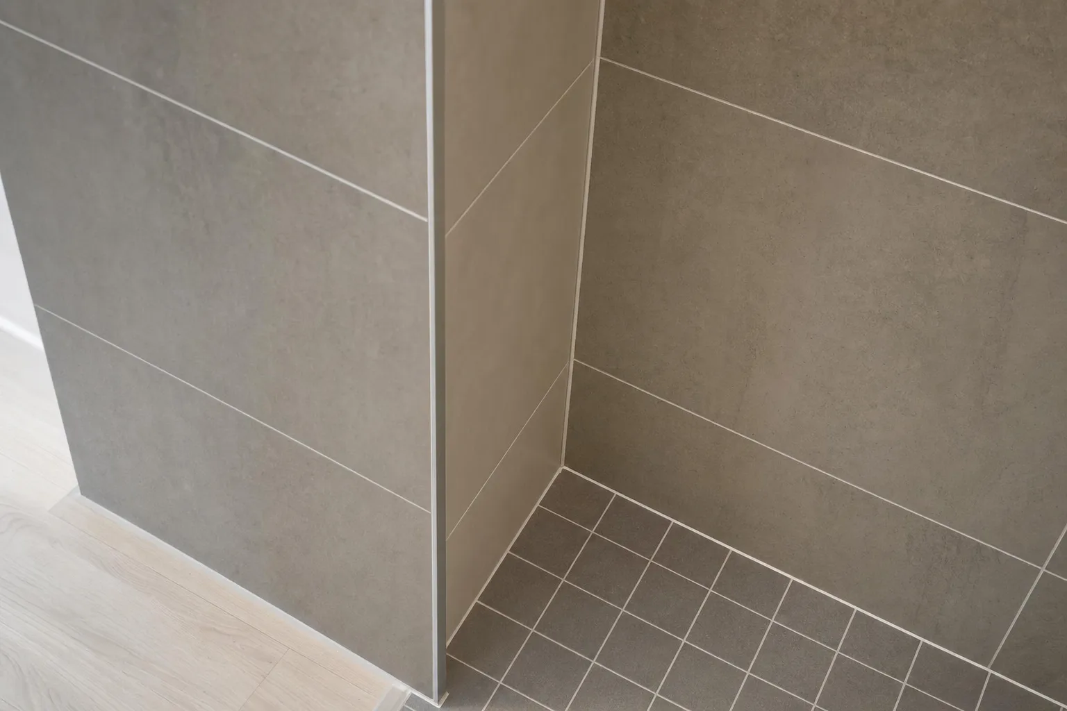 Detail van strak tegelwerk met rechte voegen in een badkamer