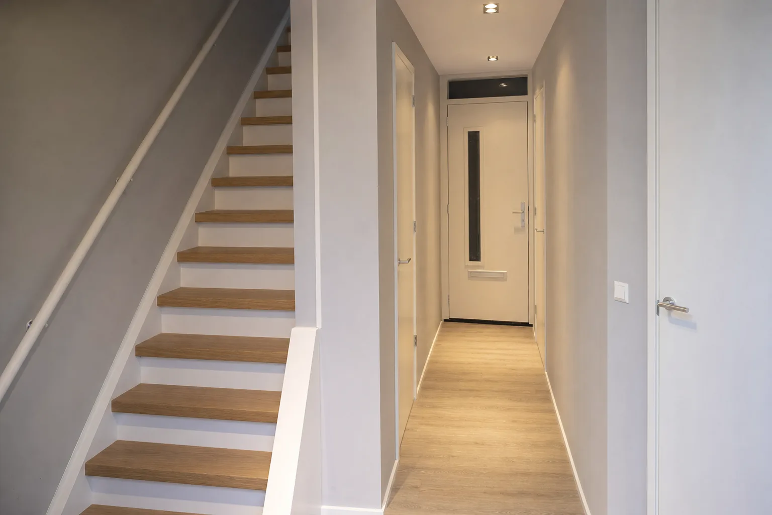 Gerenoveerde hal met nieuwe trap en strakke wanden