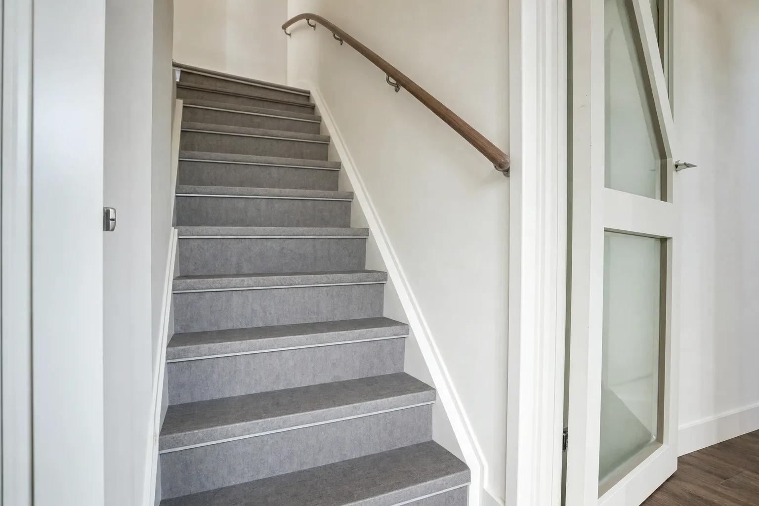Dichte trap in de hal na renovatie met nieuwe treden en leuning