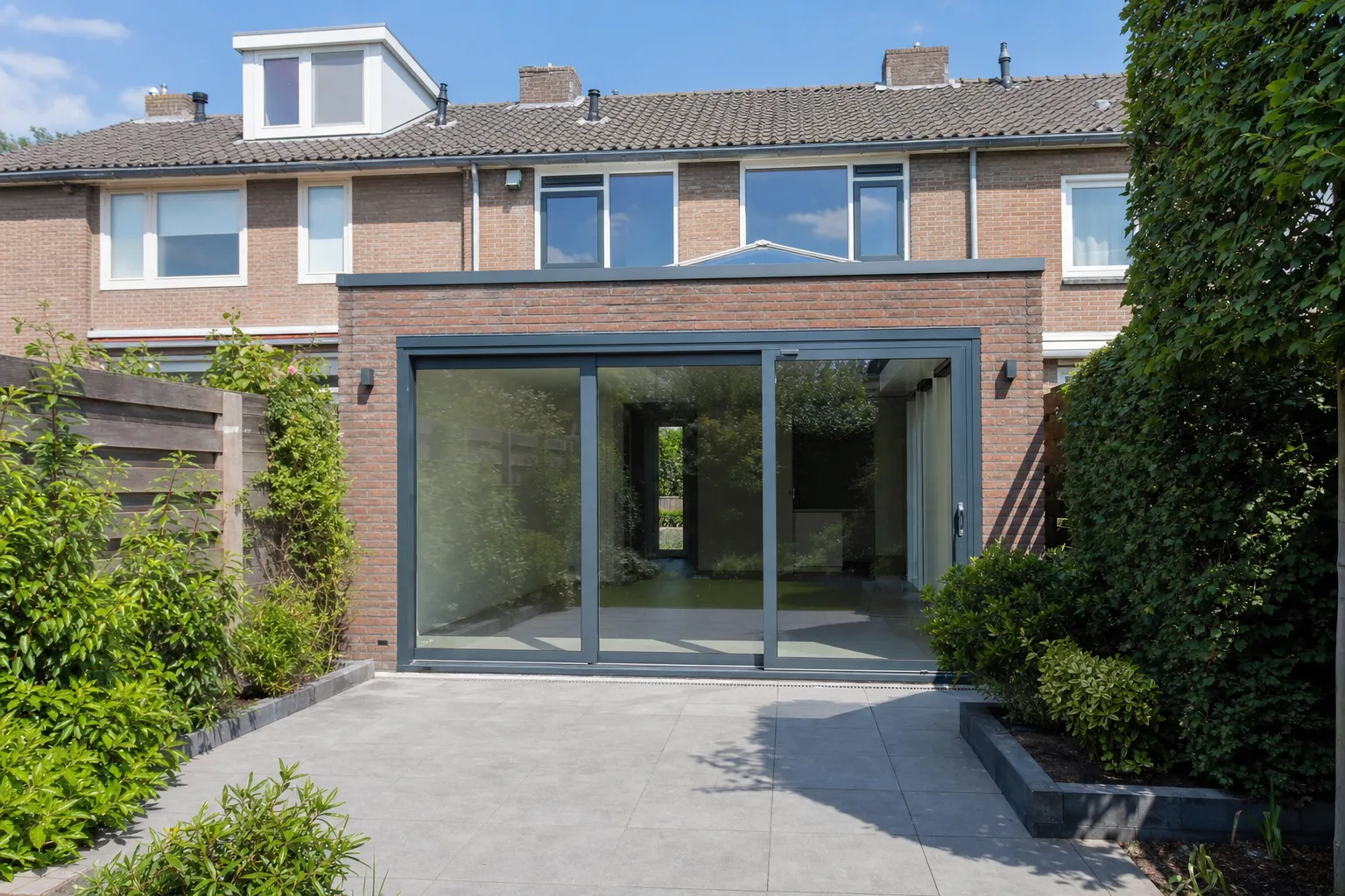 Nieuwe uitbouw met glazen schuifpui aan een rijtjeswoning in Utrecht