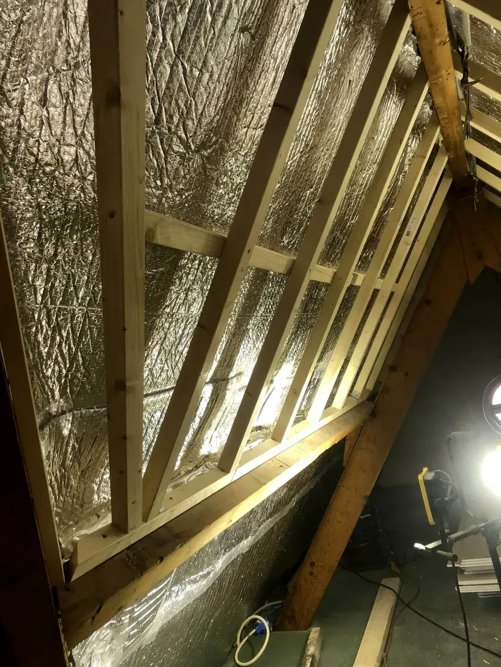 Dakisolatie met reflecterende folie tussen de spanten