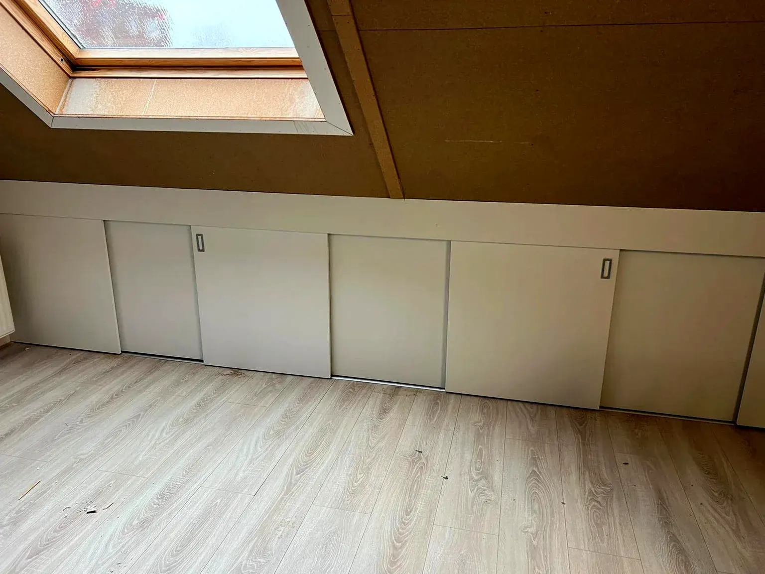 Kastwand met schuifdeuren onder het schuine dak