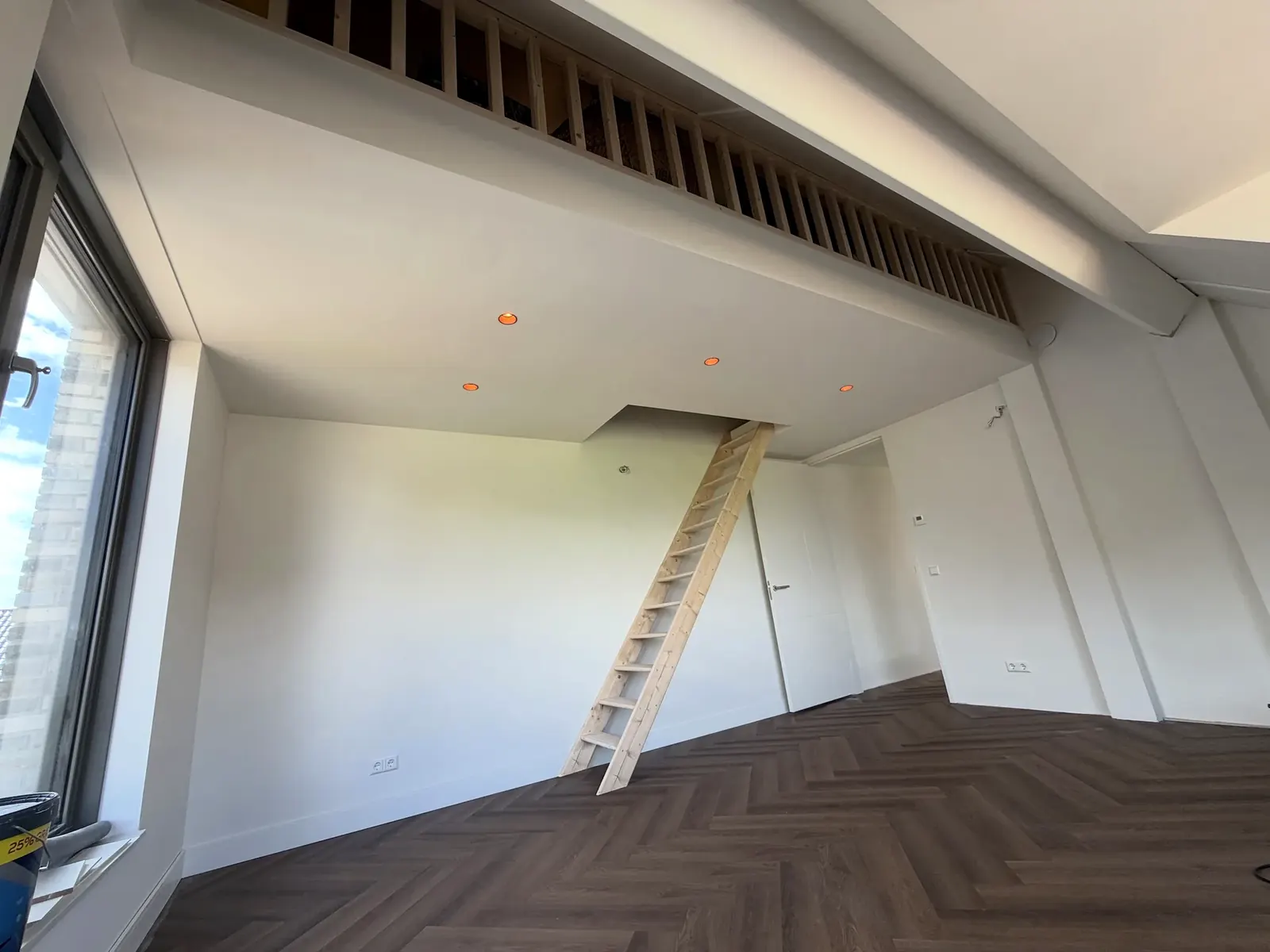 Vliering met vaste trap boven een zolderkamer met visgraatvloer