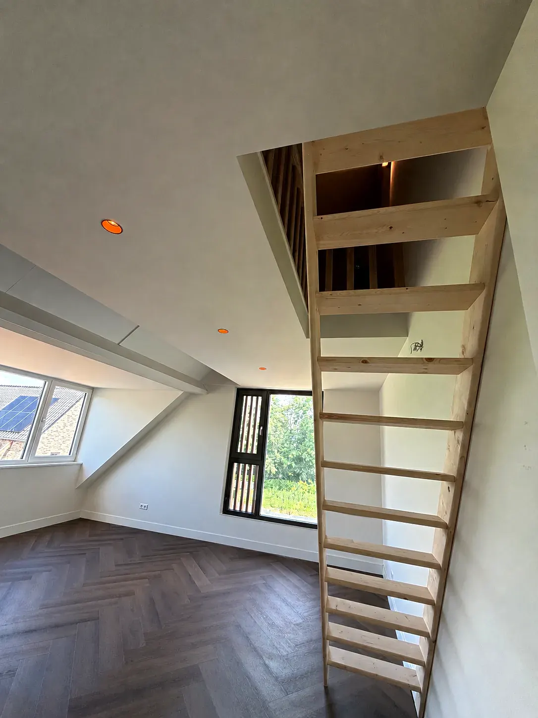 Houten vlieringtrap in een zolderkamer
