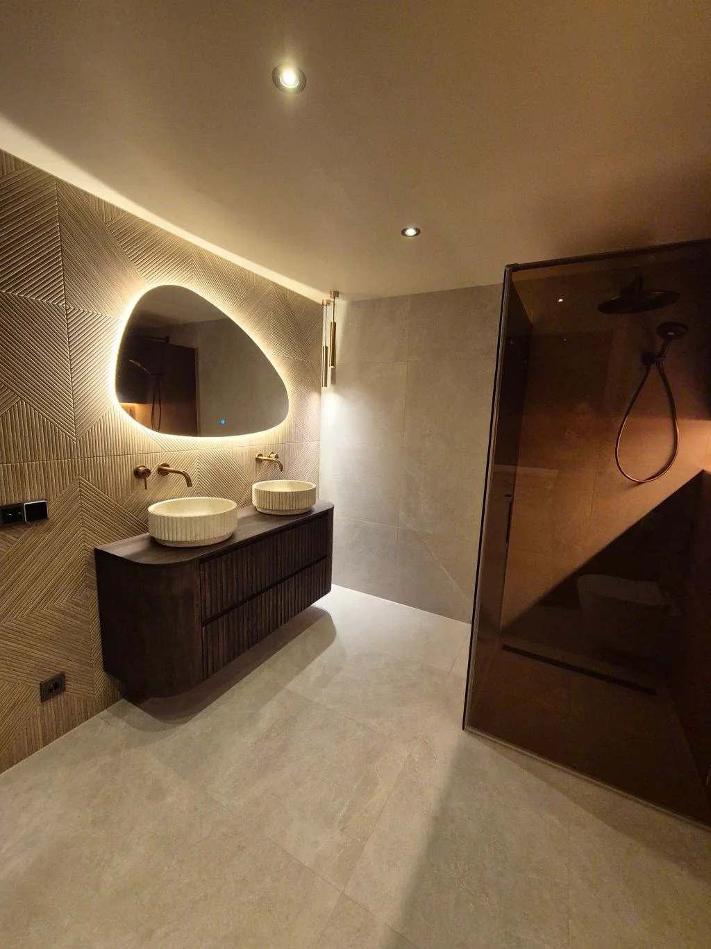 Dubbel badmeubel met verlichte spiegel in een badkamer op zolder