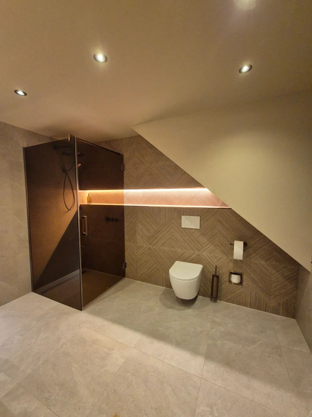 Inloopdouche en toilet onder het schuine dak met verlichte nis