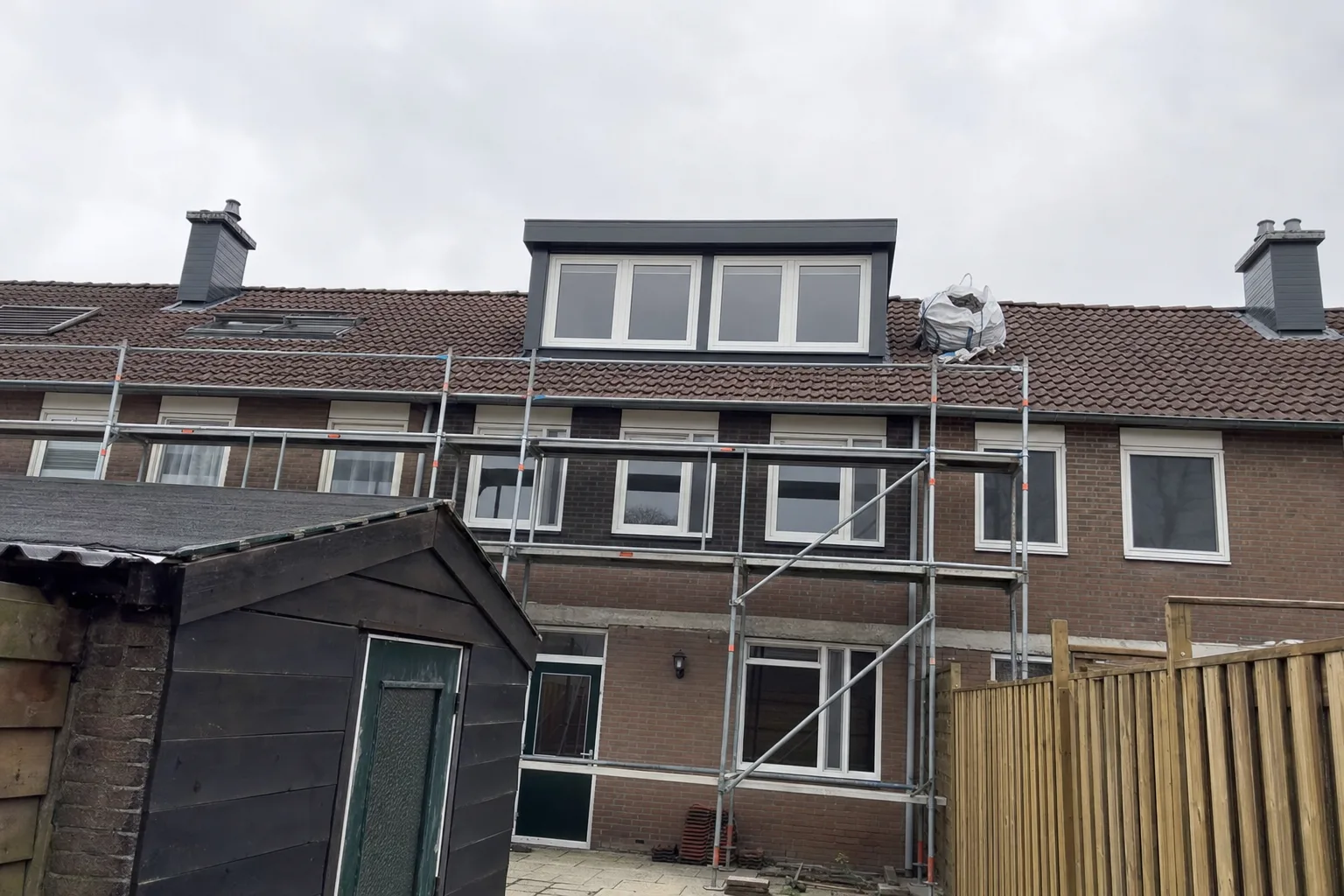 Pannendak van een rijtjeshuis met dakkapel aan de achterkant