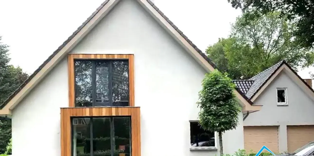 Vrijstaand wit huis na een renovatie met houten kozijnlijsten