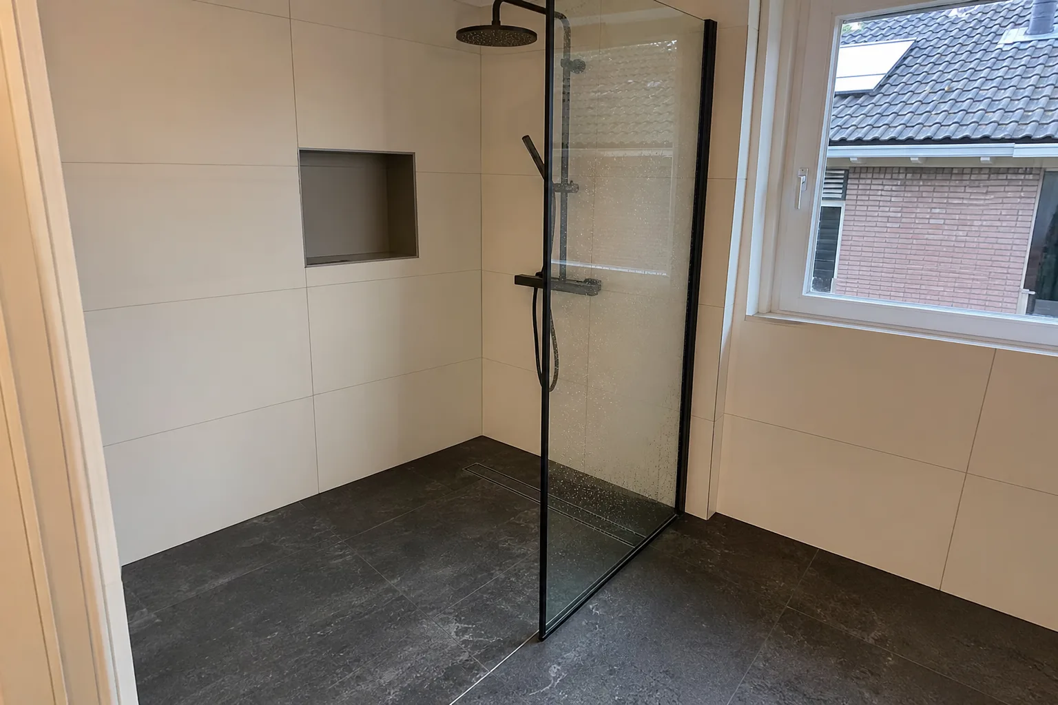 Drempelloze inloopdouche met glazen wand en zwart profiel