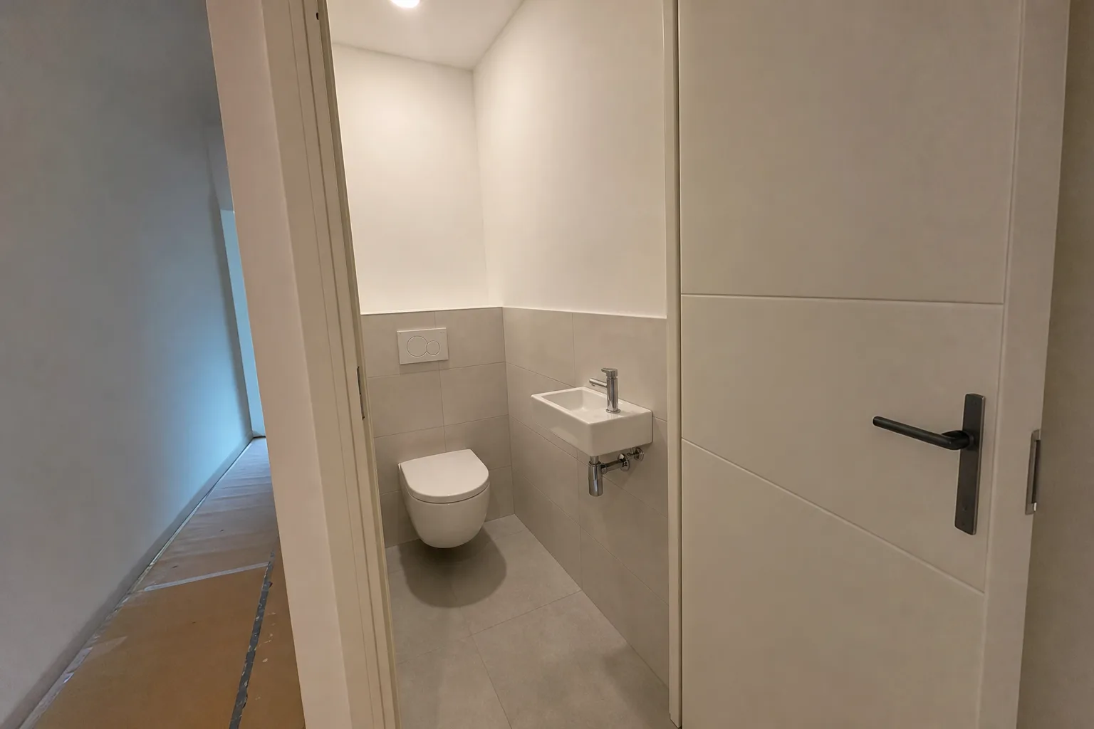 Hangtoilet met strak tegelwerk in een kleine toiletruimte
