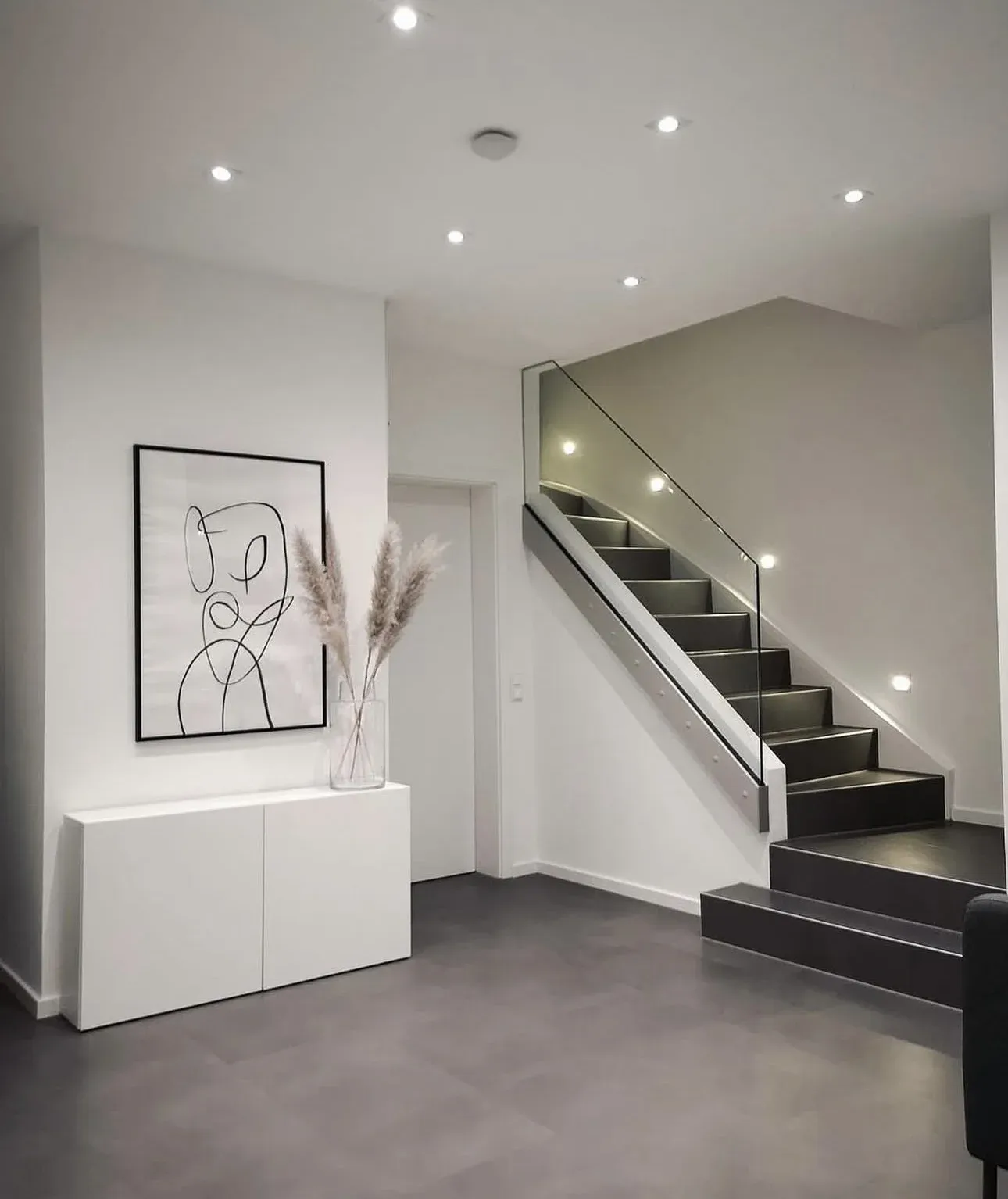 Witte hal met dichte trap en glazen balustrade
