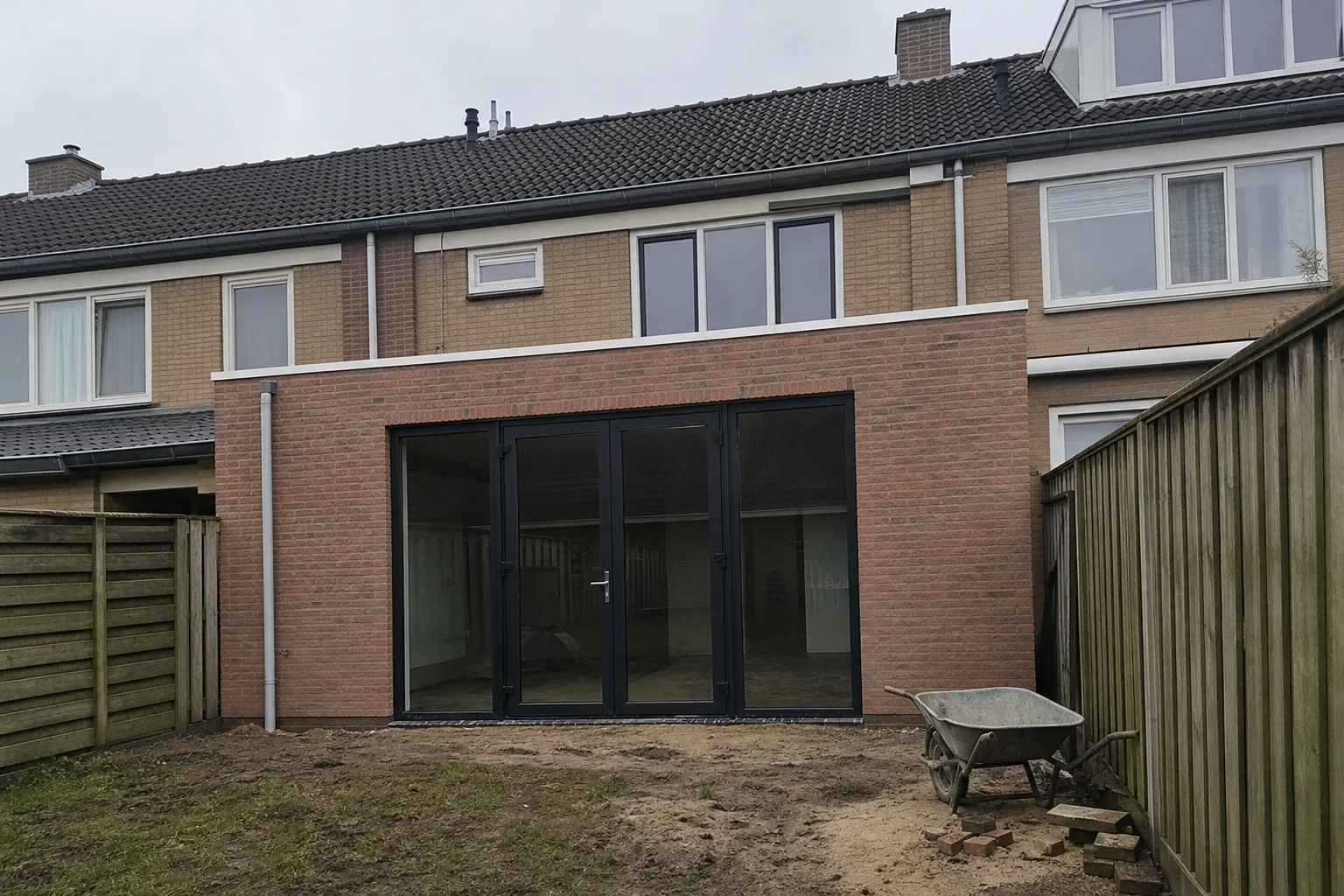 Uitbouw aan een rijtjeshuis tegen de erfgrens met de buren