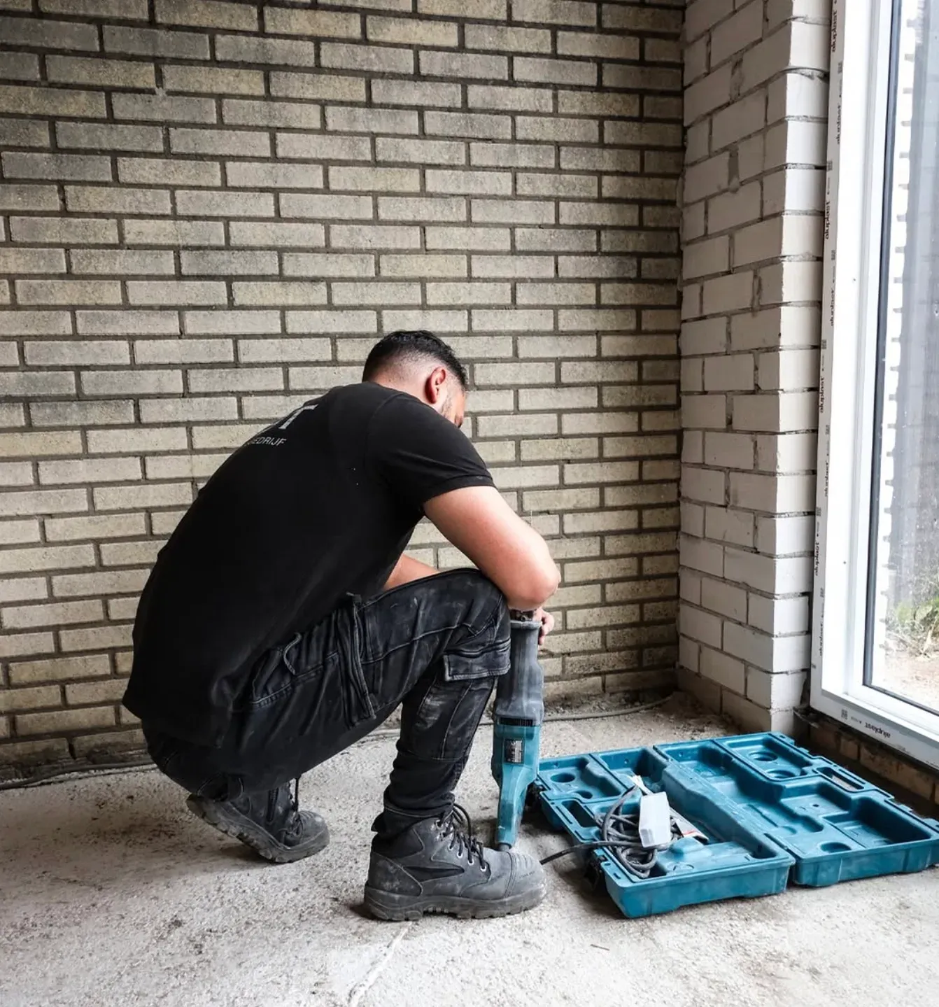 Vakman van MBT aan het werk op een vloer tijdens een renovatie